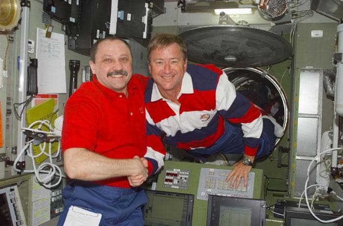 NASA image: Usachev shakes Culbertson's hand in ISS Service Module/Zvezda module