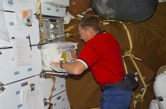NASA image: Culbertson pulls out the stowage bag labeled DREAMTiME equipment