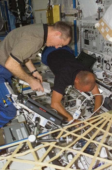 NASA image: Sturckow and Voss transfer the APCF stowage bag to the ISS U.S. Laboratory/Destiny