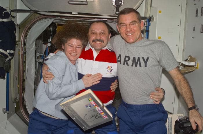 NASA image: Helms, Usachev and Voss pose with the ISS Ships Log
