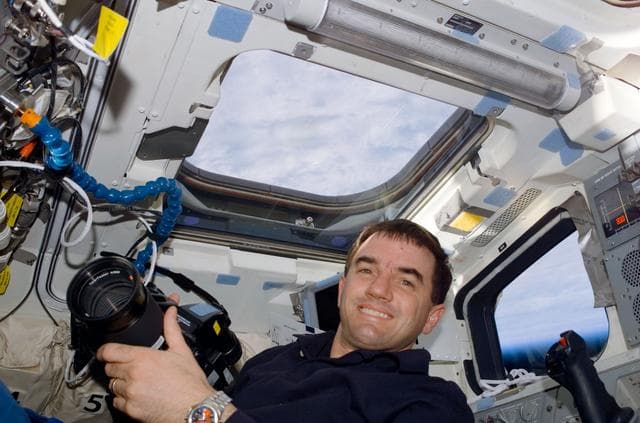 NASA image: MS Walheim poses with a Hasselblad camera on the flight deck of Atlantis during STS-110