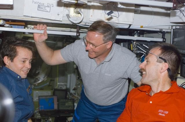 NASA image: Bursch, Ross and Smith talk in Zvezda during STS-110's visit to the ISS