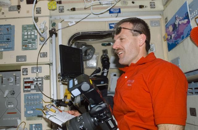 NASA image: Smith with a notebook and camera in Zvezda during STS-110's visit to the ISS
