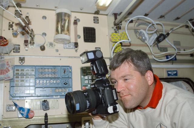 NASA image: Frick uses a 35mm camera in Zvezda during STS-110's visit to the ISS