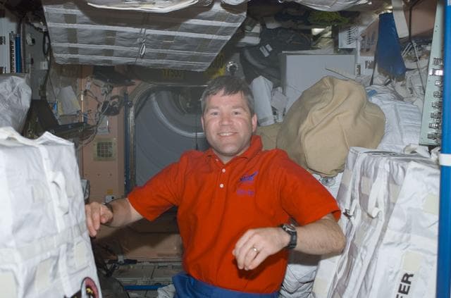 NASA image: Frick poses among SAFER stowage bags in Node 1 during STS-110's visit to the ISS