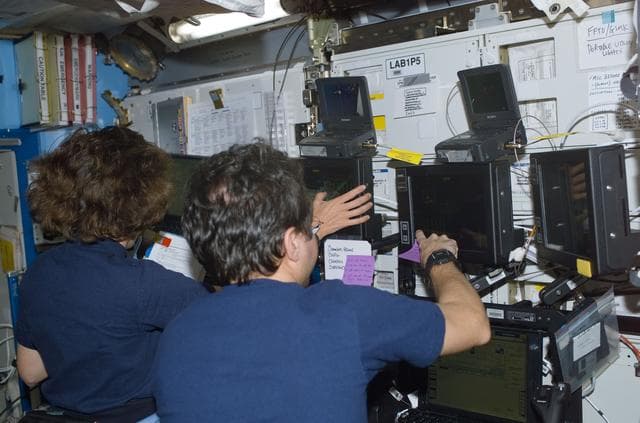 NASA image: Bursch and Ochoa at the SSRMS controls in Destiny during S0 Truss installation on the ISS