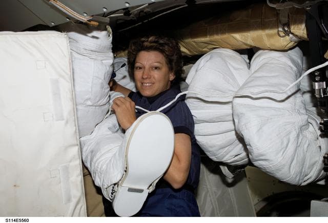 NASA image: Collins on middeck with EMU equipment