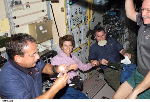 NASA image: STS-114 and Expedition 11 crew share meal in Zvezda Service module
