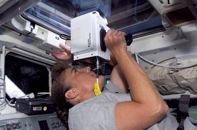 NASA image: STS-115 MS Stefanyshyn-Piper uses laser ranging device throught window in the Aft FD
