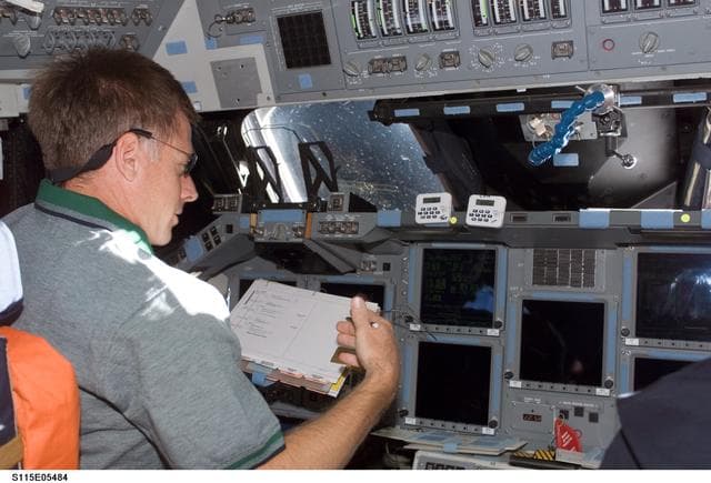 NASA image: Ferguson looks at crew procedures on the FD of the Space Shuttle Atlantis during STS-115