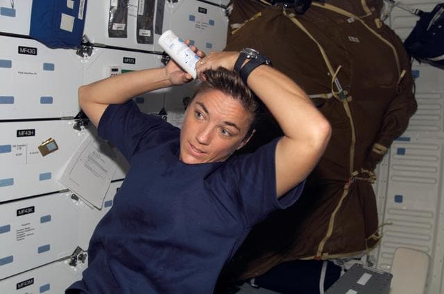 NASA image: STS-115 MS Stefanyshyn-Piper shampoos her hair in the FWD MDDK during Joint Operations