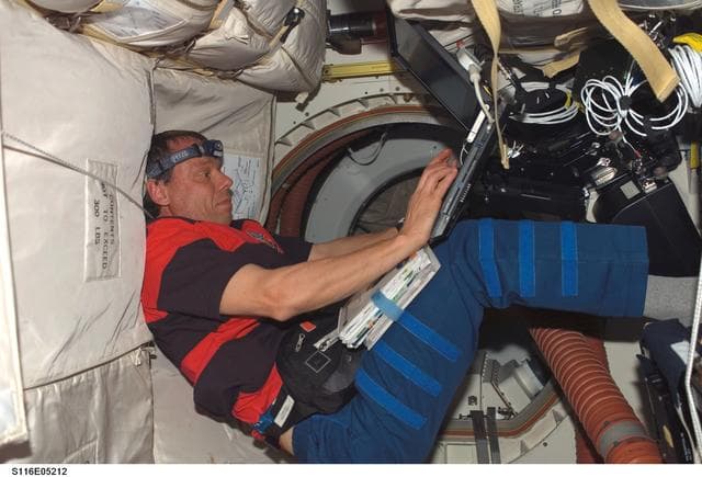 NASA image: STS-116 Pilot Oefelin uses laptop computer in the MDDK on Space Shuttle Discovery