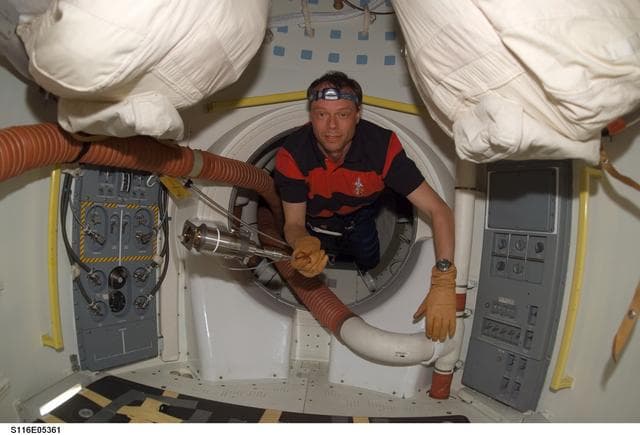 NASA image: STS-116 MS enters the airlock on Space Shuttle Discovery