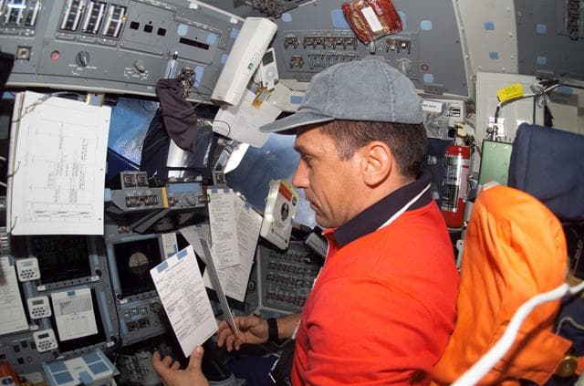 NASA image: STS-116 Pilot Oefelein looks at crew procedures on Space Shuttle Discovery