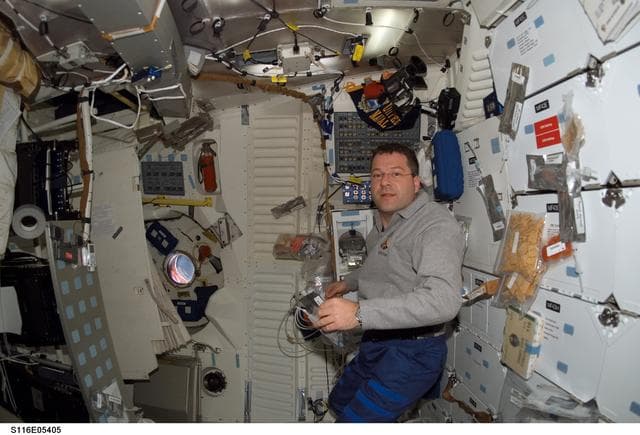 NASA image: STS-116 MS holding food packet in the FWD MDDK on Space Shuttle Discovery