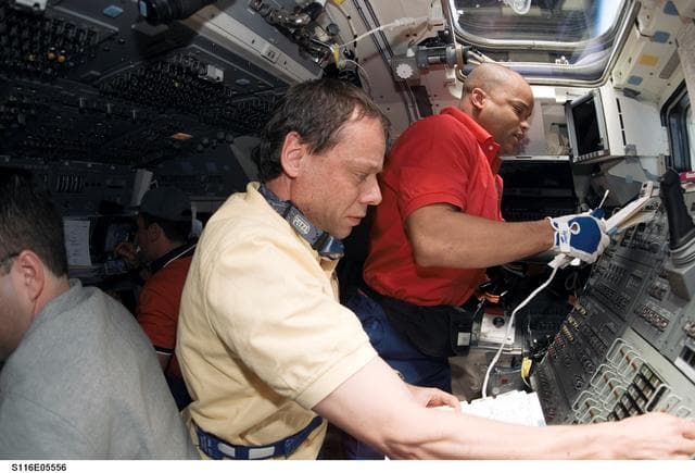 NASA image: STS-116 Crewmembers work with controls in the aft FD on Space Shuttle Discovery
