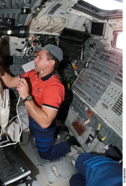 NASA image: STS-116 Pilot Oefelein uses communication equipment in the aft FD on Space Shuttle Discovery