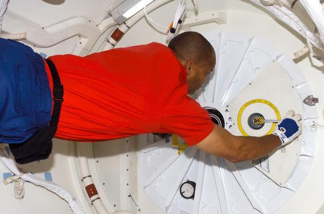 NASA image: STS-116 MS Curbeam,Jr., prepares to open hatch on Space Shuttle Discovey