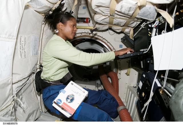 NASA image: STS-116 MS Higginbotham uses laptop computer in the MDDK on Space Shuttle Discovery