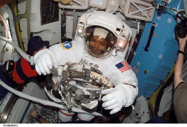 NASA image: STS-116 MS Curbeam removes his EMU in the A/L on the ISS