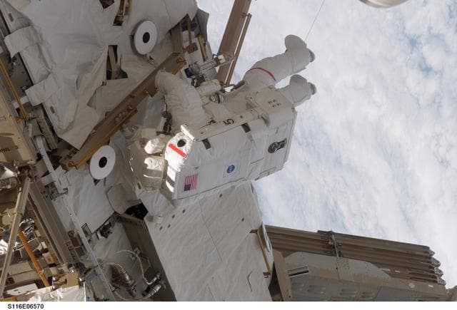 NASA image: STS-116 MS Curbeam, Jr., works on the S0 and S1 Truss during EVA 3