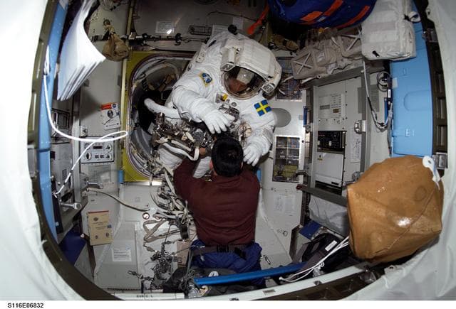 NASA image: STS-116 Pilot Oefelein assists STS-116 MS Fuglesang with his EMU during Joint Operations