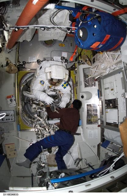 NASA image: STS-116 Pilot Oefelein assists STS-116 MS Fuglesang with his EMU during Joint Operations