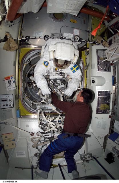 NASA image: STS-116 Pilot Oefelein assists STS-116 MS Fuglesang with his EMU during Joint Operations