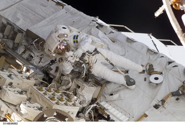 NASA image: STS-116 MS Fuglesang uses digital camera on the STBD side of the S0 Truss during EVA 4