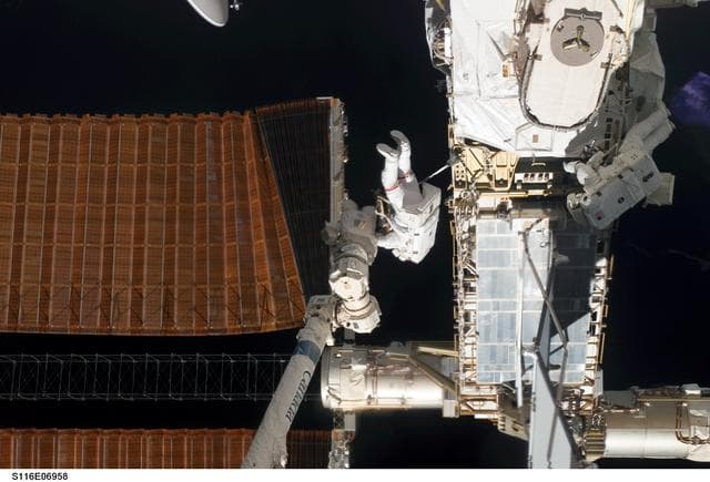 NASA image: STS-116 MS Curbeam and Fuglesang work with port OVHD SAW on the P6 Truss during EVA-4