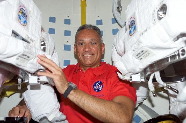 NASA image: Olivas poses with EMUs on the MDDK of STS-117 Space Shuttle Atlantis