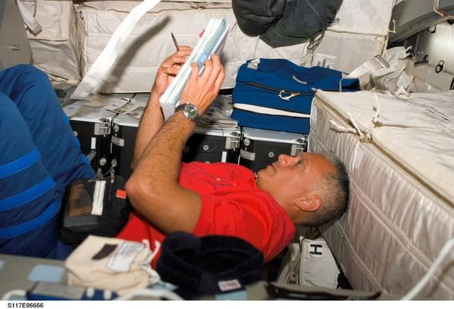 NASA image: Olivas looks over crew procedures on the MDDK of STS-117 Space Shuttle Atlantis