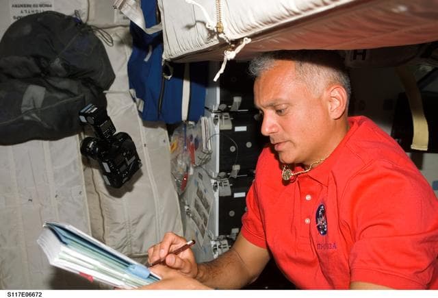 NASA image: Olivas looks at crew procedures on the MDDK of STS-117 Space Shuttle Atlantis