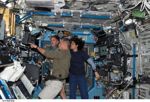 NASA image: STS-117 and Expedition 15 crewmembers in the U.S. Laboratory during Joint Operations