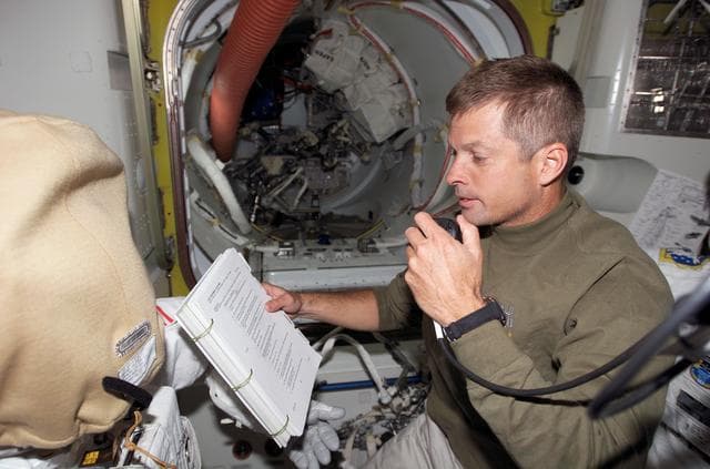NASA image: Swanson uses communication equipment in the A/L during Joint Operations