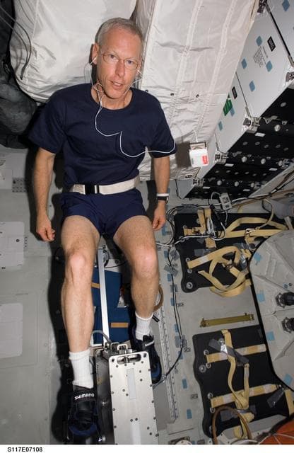 NASA image: Forrester exercises on a bicycle ergometer on the MDDK of Space Shuttle Atlantis during Joint Operations