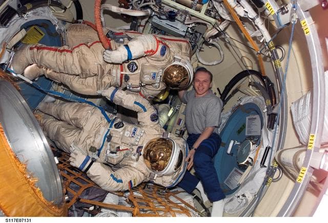 NASA image: Kotov poses with Russian Orlan Spacesuits in the Pirs DC1 during Joint Operations