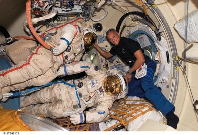 NASA image: Olivas poses with Russian Orlan Spacesuits in the Pirs DC1 during Joint Operations