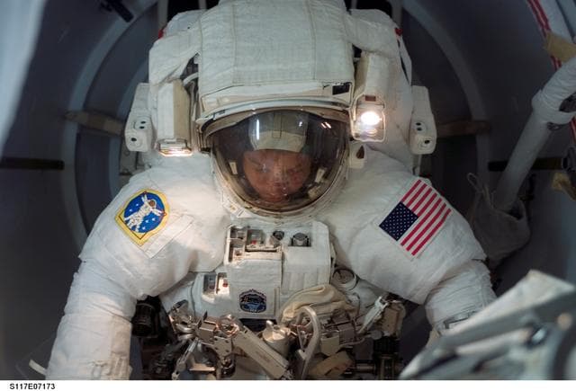 NASA image: Swanson wears EMU in the A/L during Joint Operations