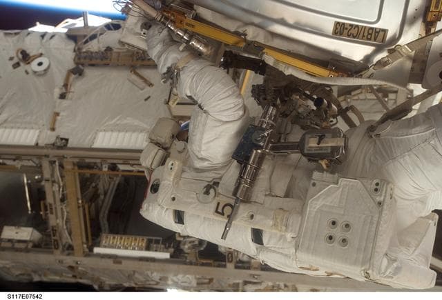 NASA image: Reilly installs a water to hydrogen vent on the outside of the U.S. Laboratory during EVA 3