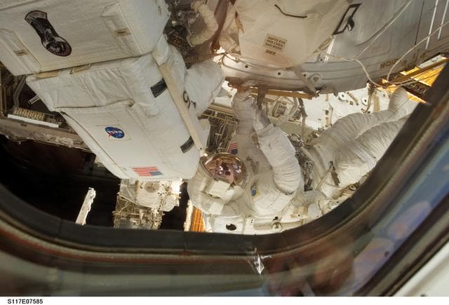 NASA image: Reilly and Olivas install a water to hydrogen vent on the outside of the U.S. Laboratory during EVA 3