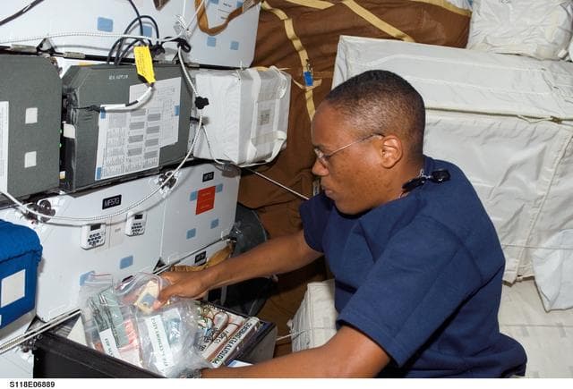 NASA image: View of Drew stowing a FDF Accessory Kit in the MDDK during STS-118