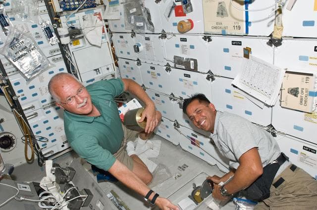 NASA image: Phillips and Acaba with Lithium Hydroxide (LiOH) canisters on Middeck (MDDK)