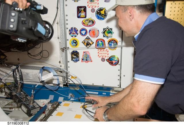 NASA image: Archambault places STS-119 patch in Node 1 Unity