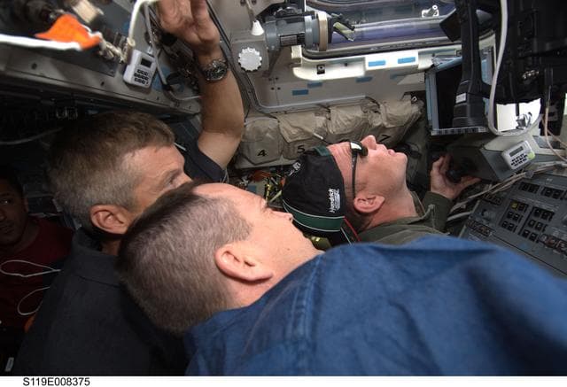 NASA image: Swanson, Arnold, and Antonelli lt on Flight Deck (FD) during ISS Flyaround
