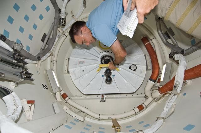 NASA image: Archambault and Phillips work to close shuttle airlock hatch