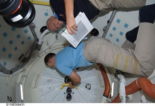 NASA image: Archambault and Phillips work to close shuttle airlock hatch