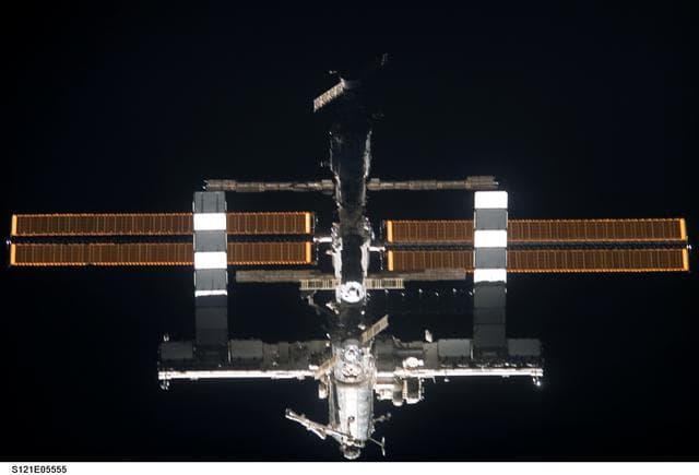 Nadir view of the ISS as the orbiter Discovery moves in for docking during STS-121