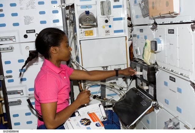 NASA image: Wilson pulls out a MDK locker drawer during STS-121/ Exp. 13 joint OPS