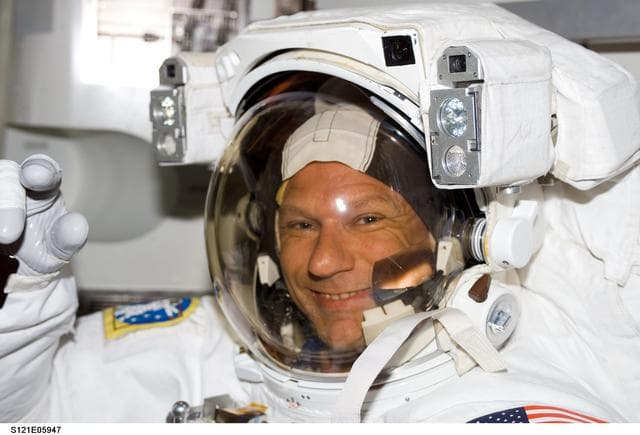 NASA image: Sellers, waves at camera, as he wears his EMU inside the A/L before EVA1 during STS-121 / Exp. 13 joint OPS